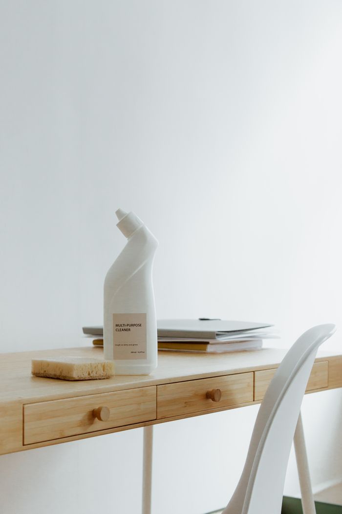 project-03-b A clean and organized home office desk with a cleaner bottle and sponge, emphasizing simplicity and functionality.
