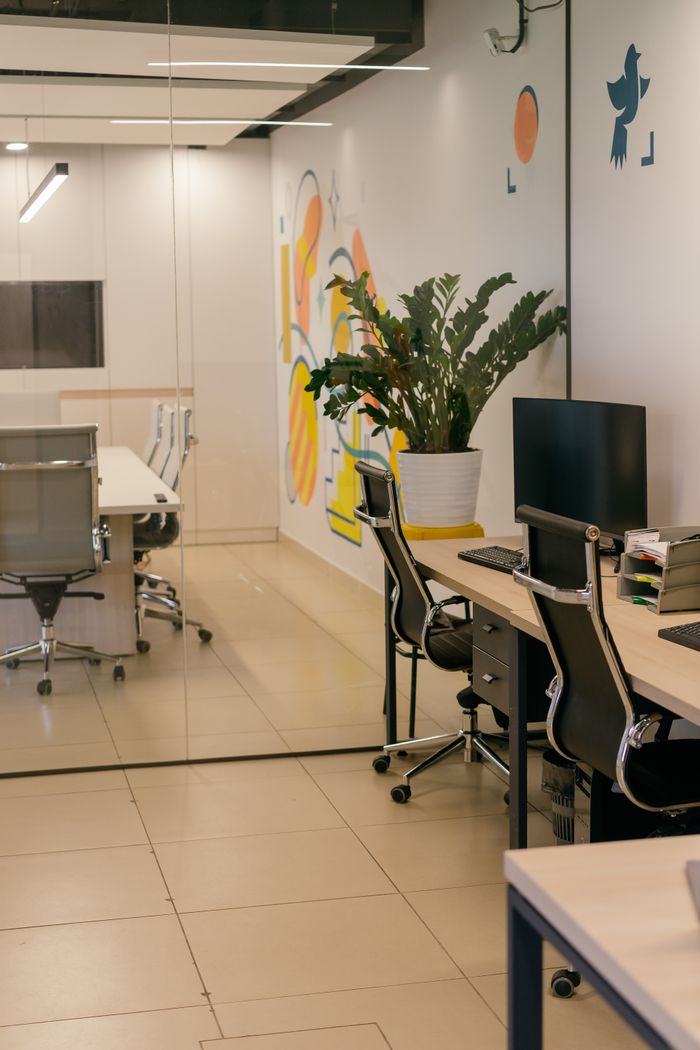 project-01-c Spacious and contemporary office interior with glass partitions, stylish furniture, and vibrant wall art.